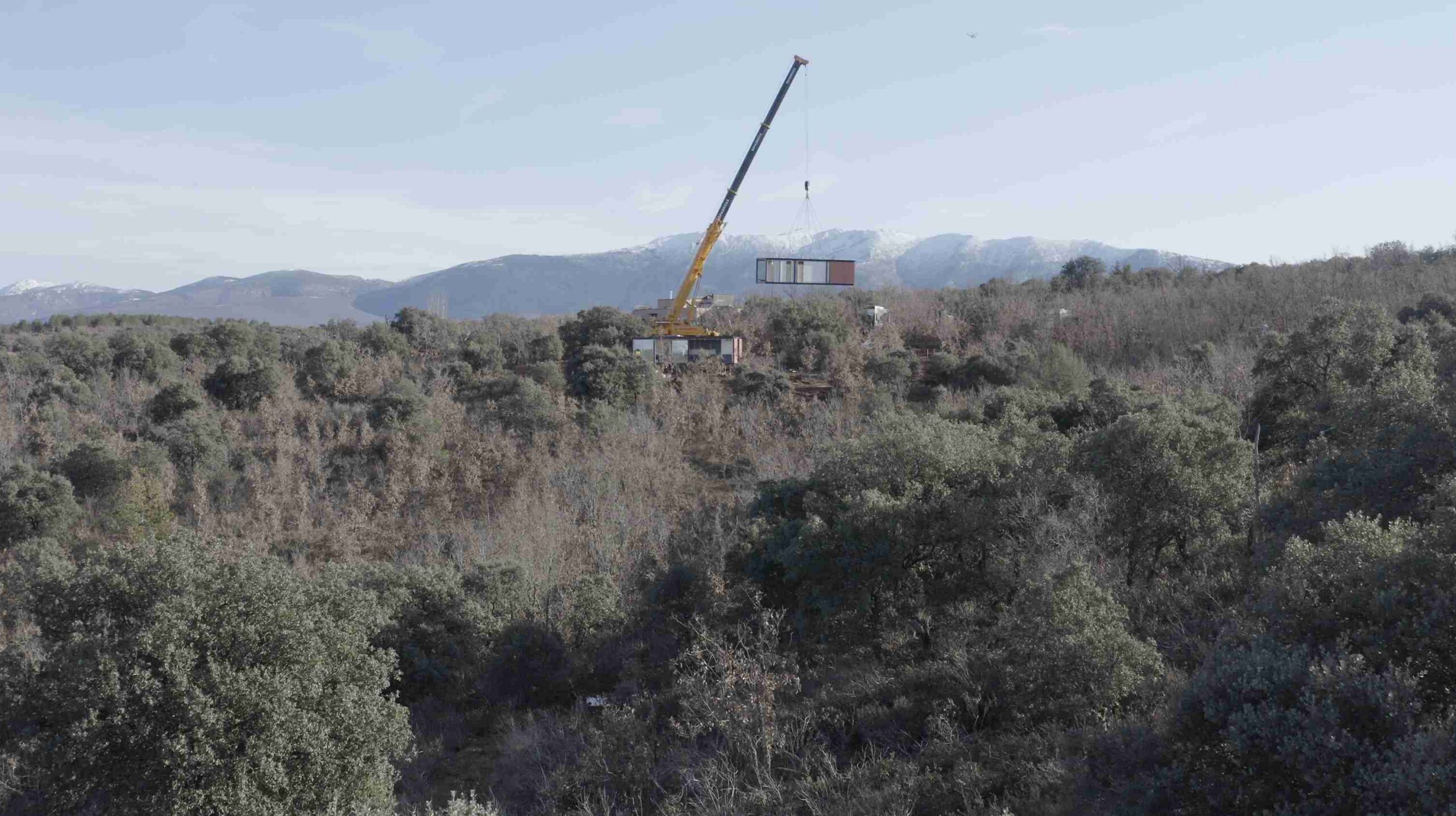 Grúa elevando un módulo sobre el valle